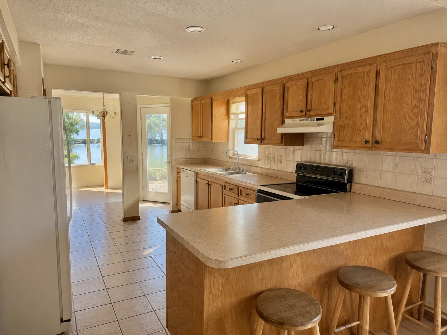 Earlier kitchen with dated oak cabinets and laminate countertop